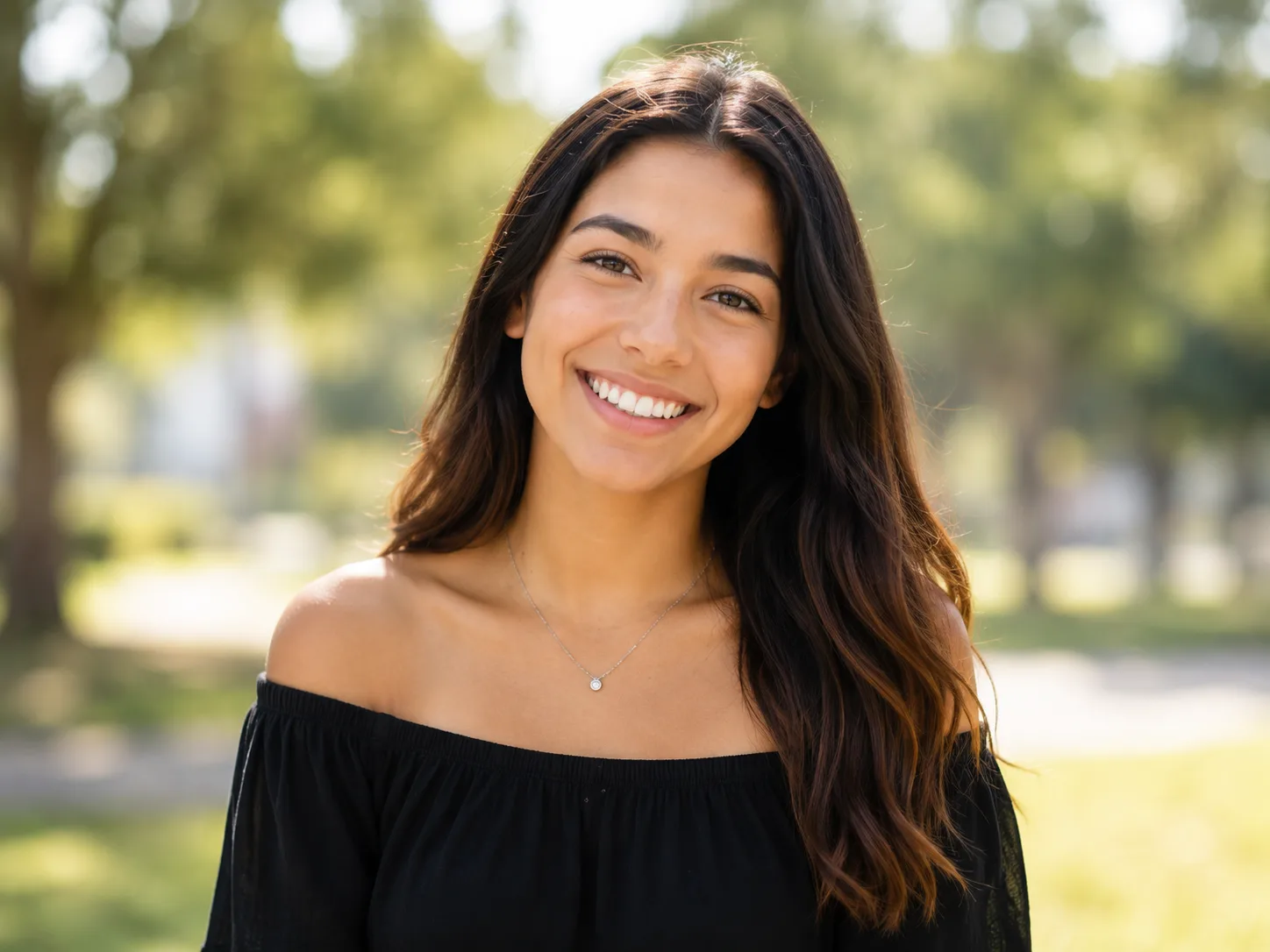 High school senior smiling outdoors for a senior portrait